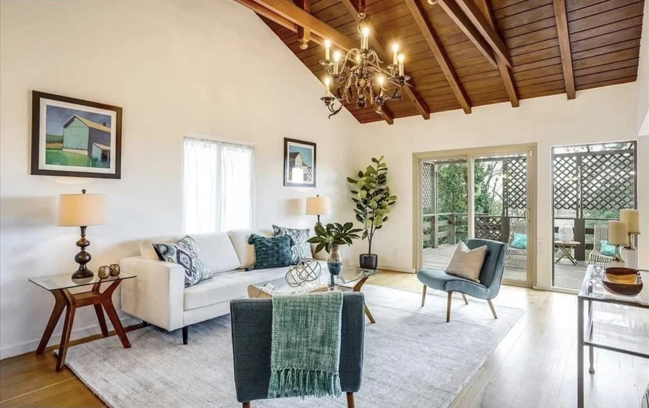 Living room with exposed wood beams and garden windows